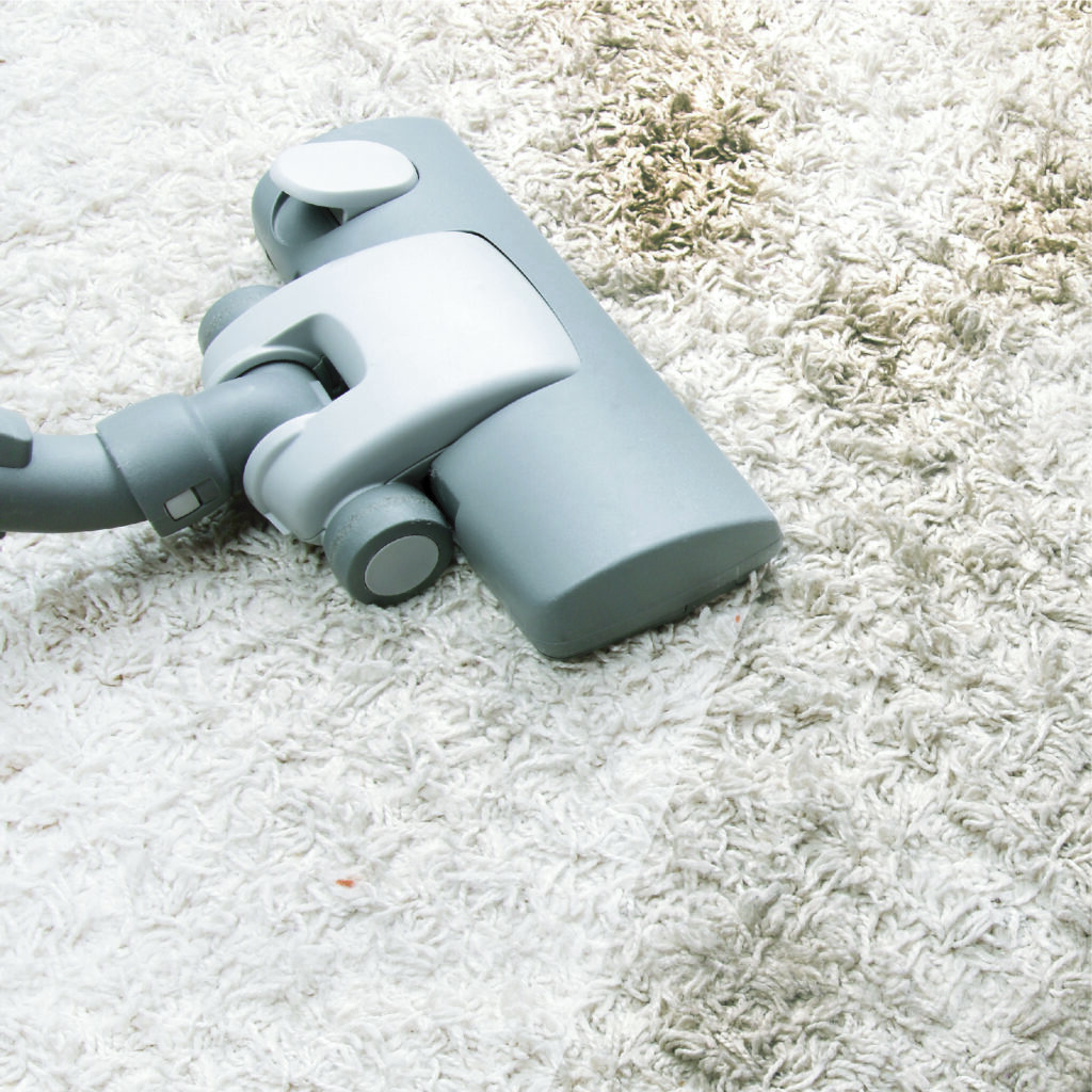 vaccum on white dirty rug - San Diego carpet cleaning service concept image