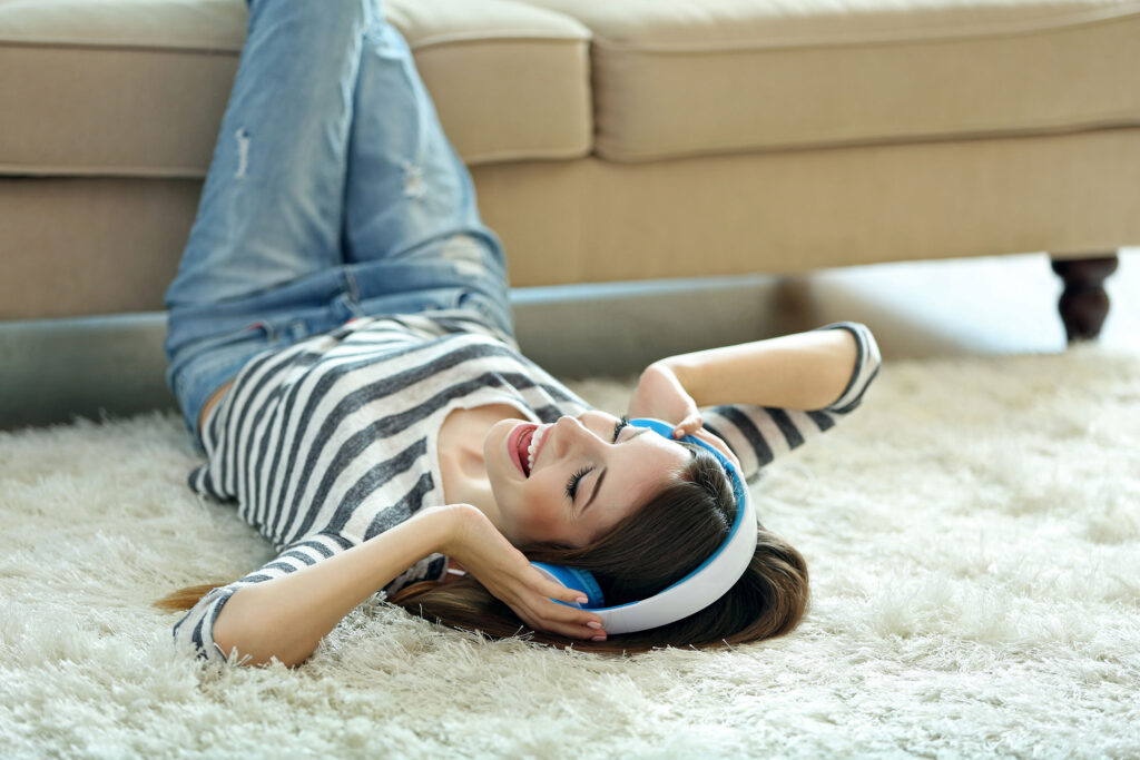 woman laying on the floor with feet on couch for carpet cleaning secrets