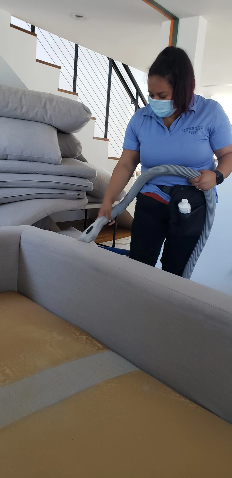 Professional furniture cleaner extracting deep stains and dust from custom fabric sofa cushions