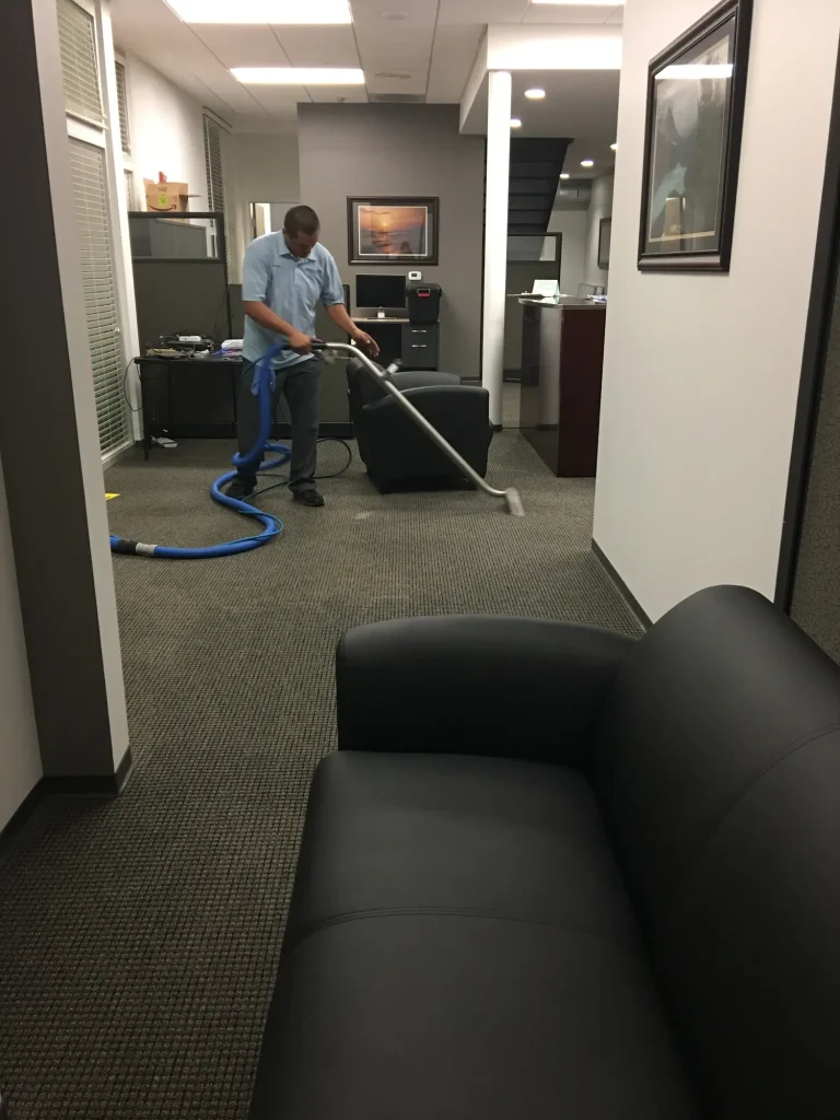 Commercial and residential carpet cleaning technician operating hot water extraction wand in San Diego